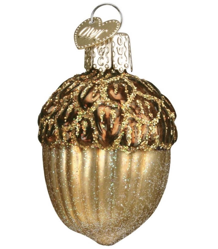 A gold acorn-shaped ornament, perfect for your Christmas tree, sparkles with glitter. It features a textured cap with intricate designs and a shiny brown and gold body, topped with a metal loop for hanging.